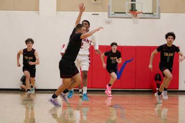 Multiple members of the Pahrump Valley High School boys basketball team attempt to get back on ...