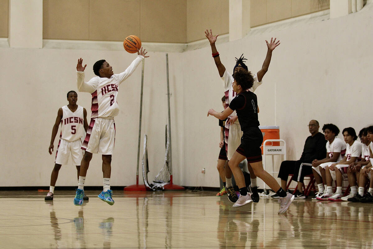Pahrump Valley High School junior Trae Plein kicks the ball out through double coverage during ...