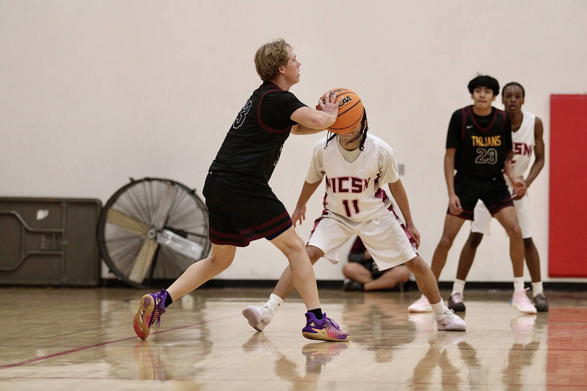 Pahrump Valley High School junior TC Hone kicks the ball out outside the perimeter to give the ...