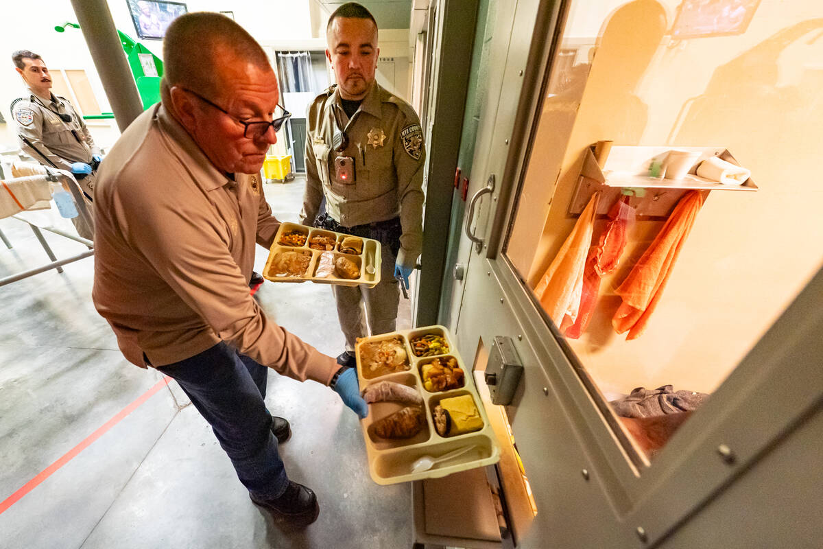 Sheriﬀ McGill sides a dinner in a food port in the door of an inmate’s cell. (John Clausen/ ...