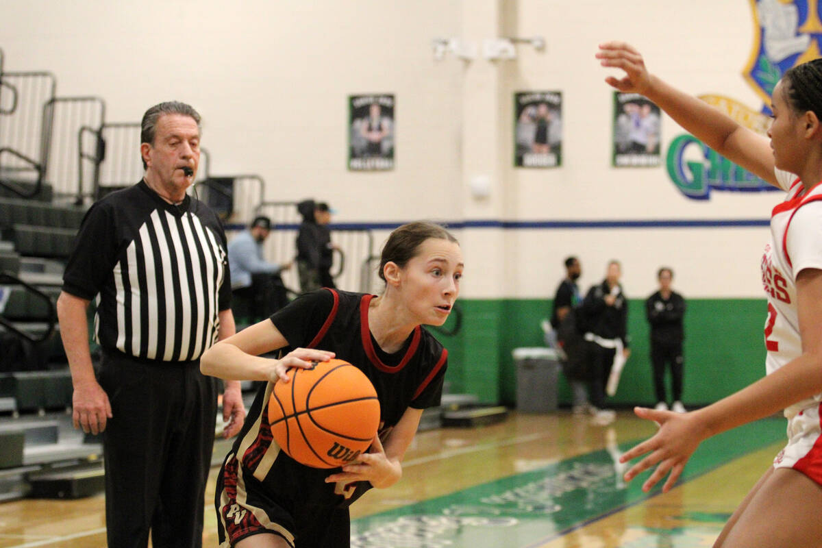 Pahrump Valley High School sophomore guard Addi Nelsen scans for a lane to drive through as she ...