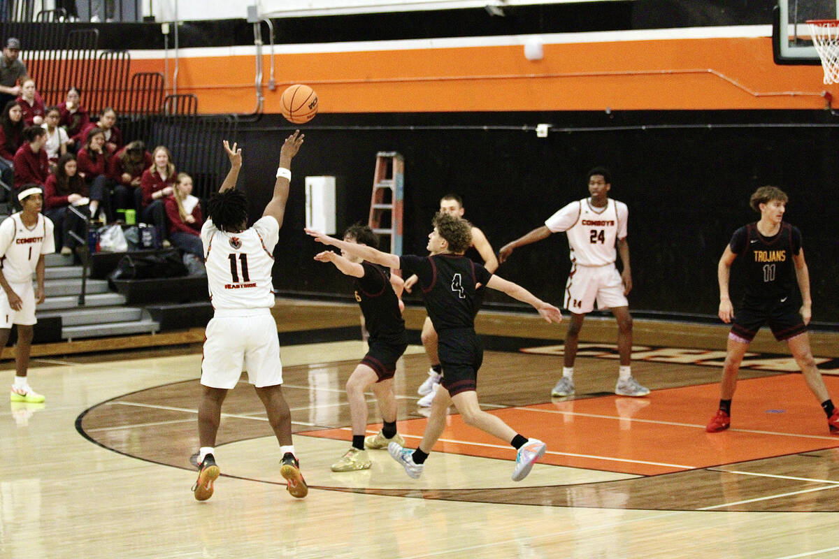 Chaparral High School junior guard Micah Jones lets one fly from three-point land despite being ...
