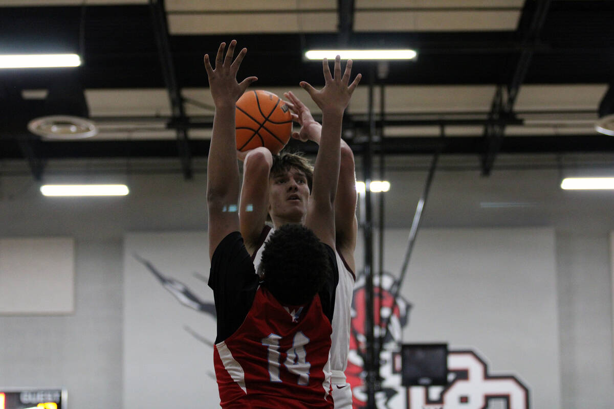 Pahrump Valley High School senior center Aydon Veloz gets a shot off amid pressure from a Weste ...