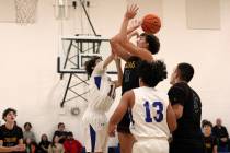 Pahrump Valley High School senior Aydon Veloz drives in for a layup in double coverage against ...