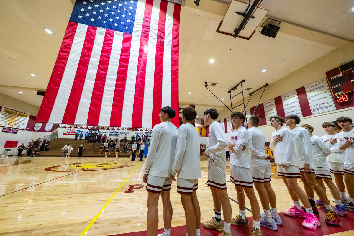 Pahrump Valley High School's varsity basketball program stands for the Pledge Of Allegiance bef ...