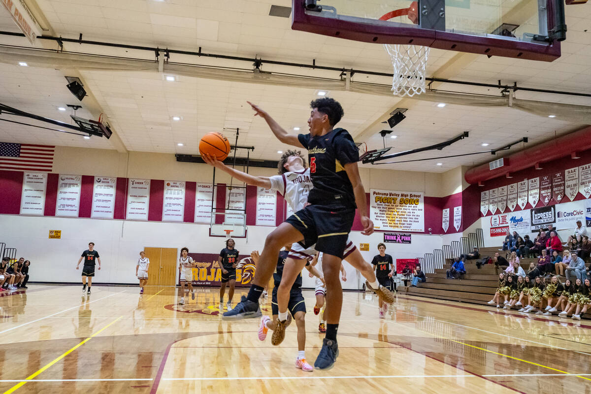 PVHS senior Keir Sheppard drives into hard contact in the paint during the Trojans' home game o ...