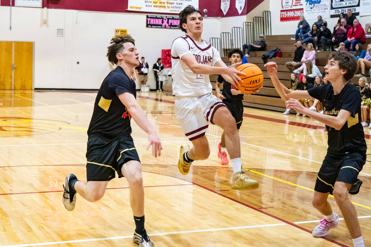 PVHS senior guard Caden Briscoe splits two SECTA defenders in pursuit of a layup during the Tro ...