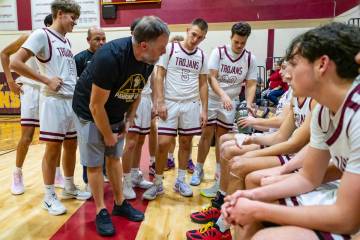 Pahrump Valley High School boys basketball head coach Toby Henry consoles the Trojans during a ...