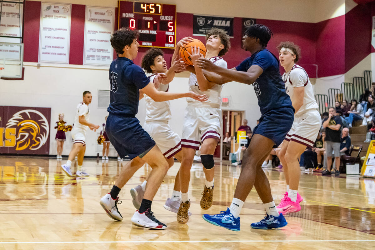 Pahrump Valley High School senior Keir Sheppard battles for control of the ball amidst two Must ...