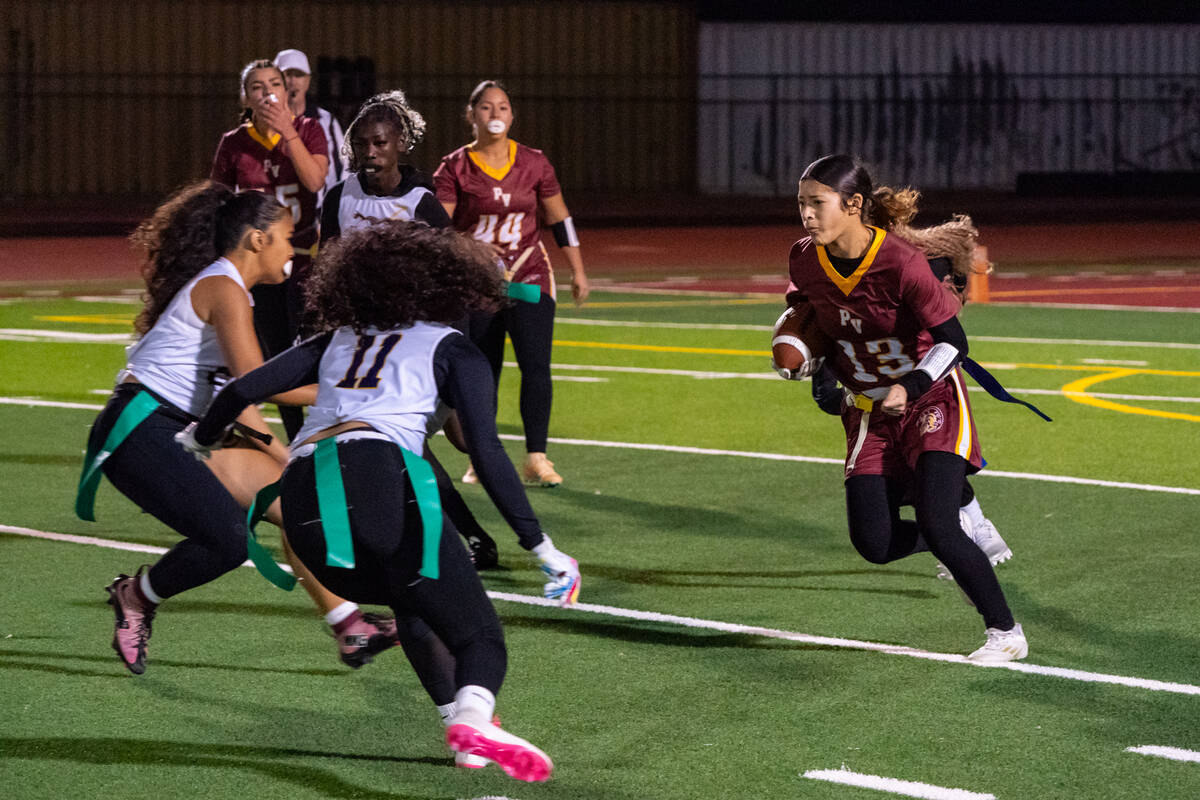Pahrump Valley High School senior DB/S Anjolina Mercado sizes up two Durango defenders as she a ...