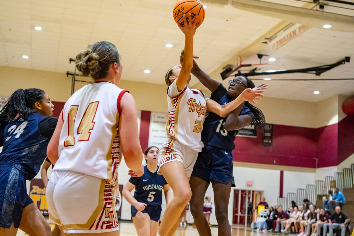 Pahrump Valley High School varsity girls basketball junior Riley Saldana is met with hard conta ...