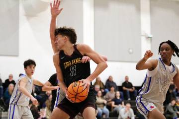 Pahrump Valley High School center Aydon Veloz is met with hard contact in the paint against GV ...