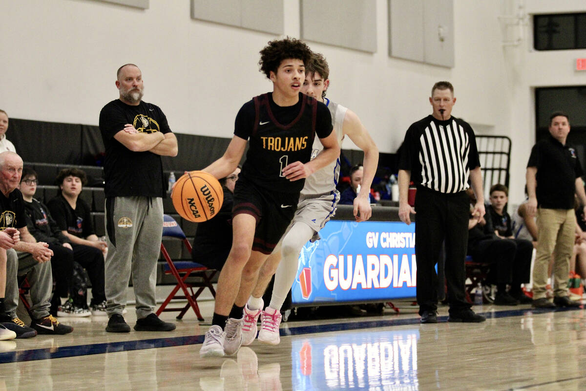 Pahrump Valley High School junior Trae Plein advances the ball up court past a Guardians defend ...