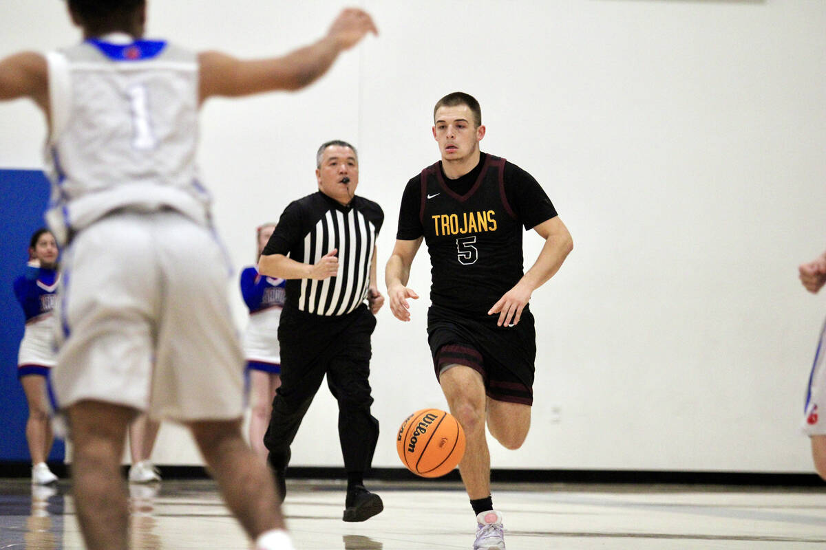 Pahrump Valley High School senior Joshua Slusher takes the ball up court after securing a rebou ...