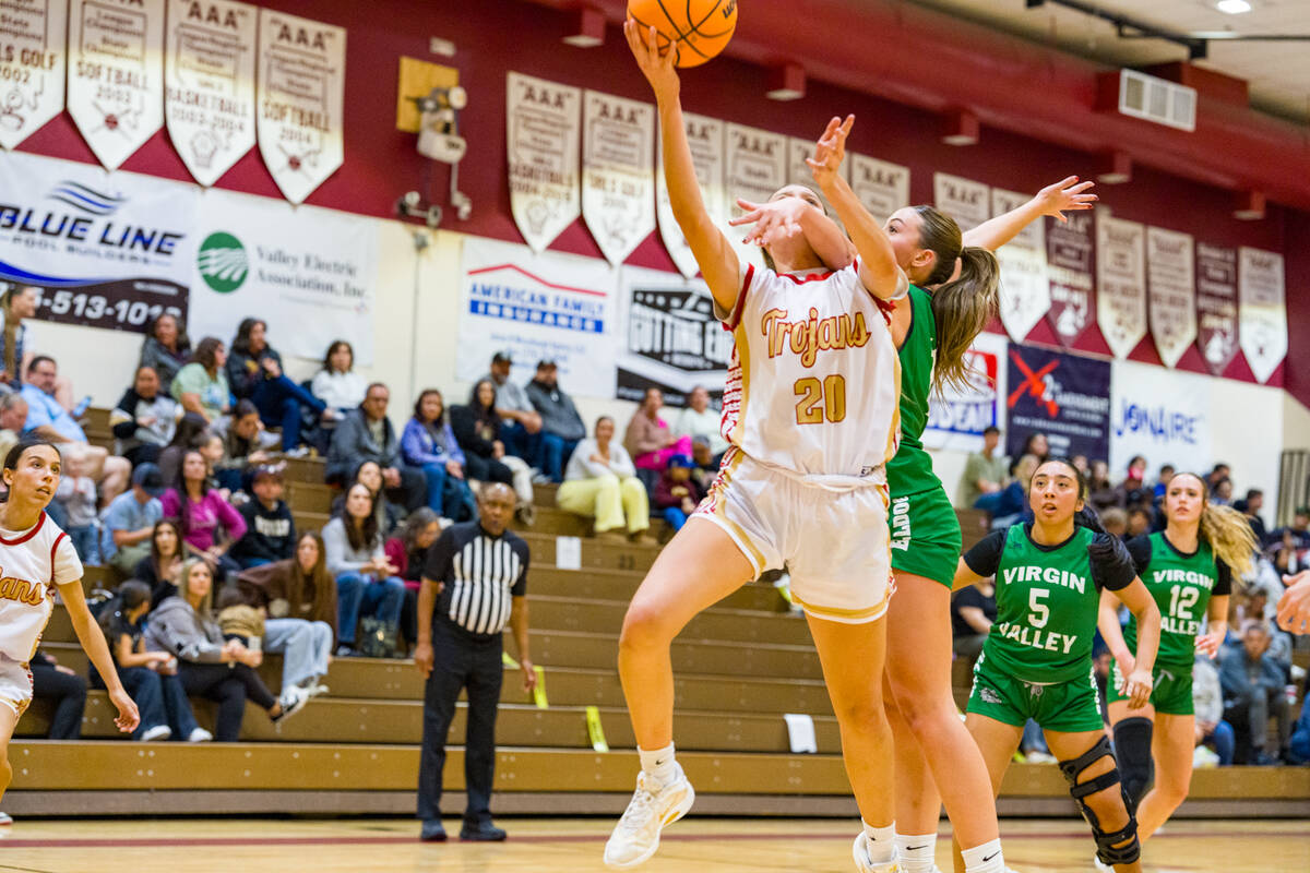 Pahrump Valley High School junior Riley Saldana does her best to finish a driving layup despite ...