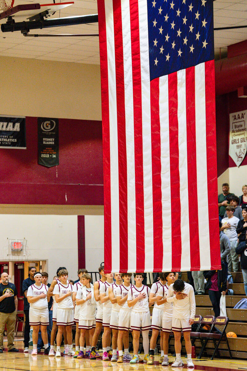 Pahrump Valley High School boys basketball team stands tall for the pledge of allegiance before ...