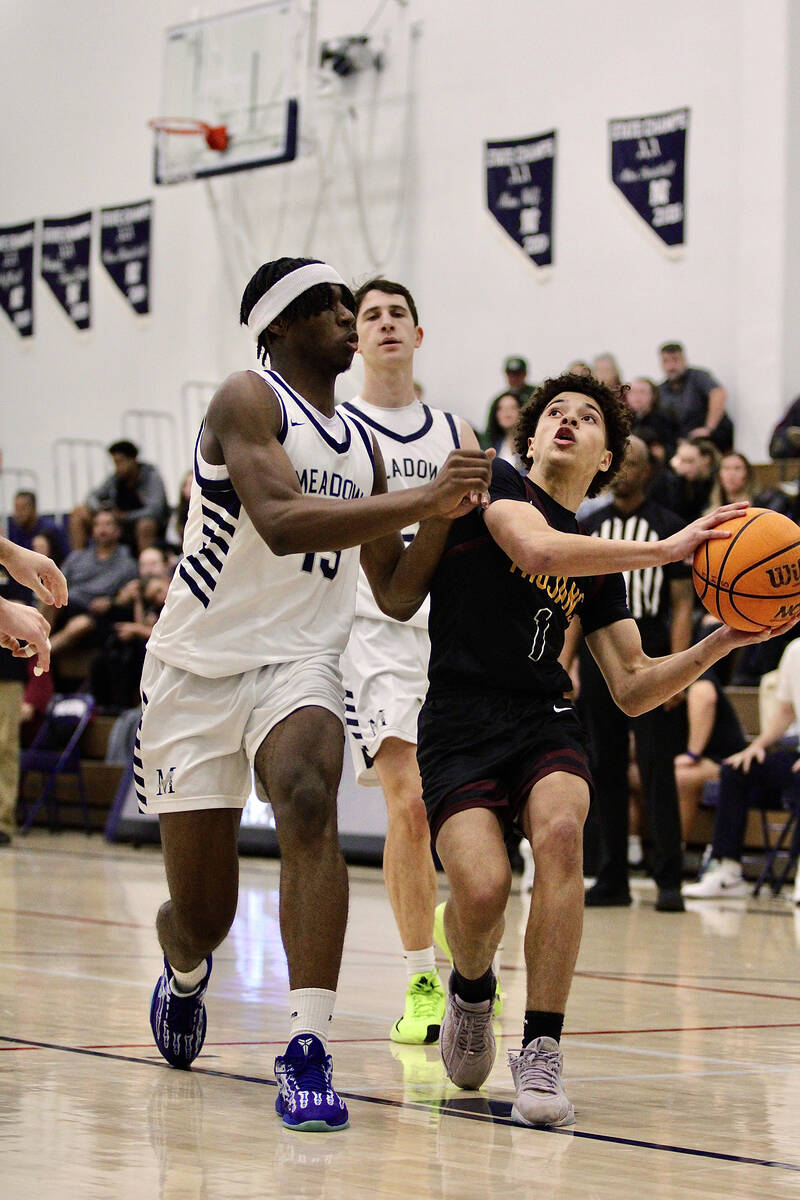 Pahrump Valley High School junior Trae Plein drives in Mustang junior Uzo Nwapa during the Troj ...