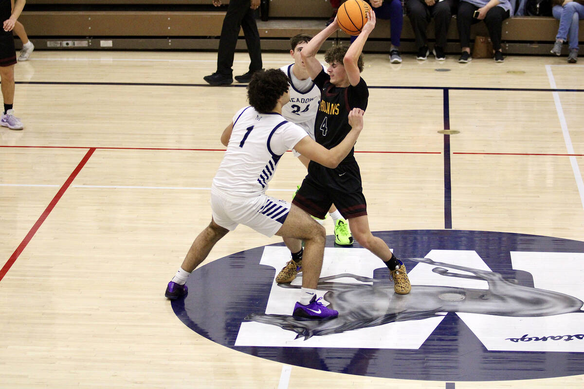 Pahrump Valley High School senior Keir Sheppard is met with pressure by The Meadows seniors Rya ...