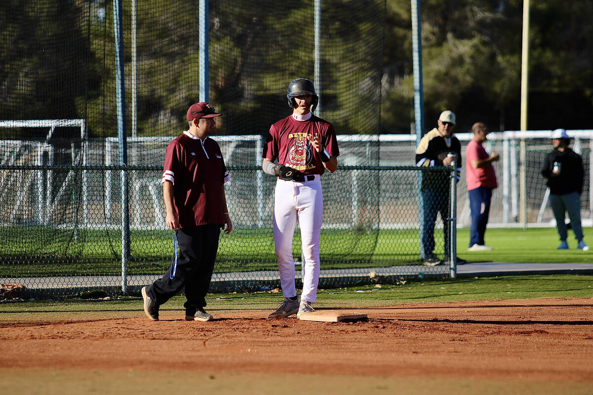 Pahrump Valley High School senior Kayne Horibe stands tall on third base while he talks to coac ...