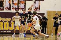 Trojans senior Keir Sheppard searches for an open look while being guarded by Boulder City soph ...