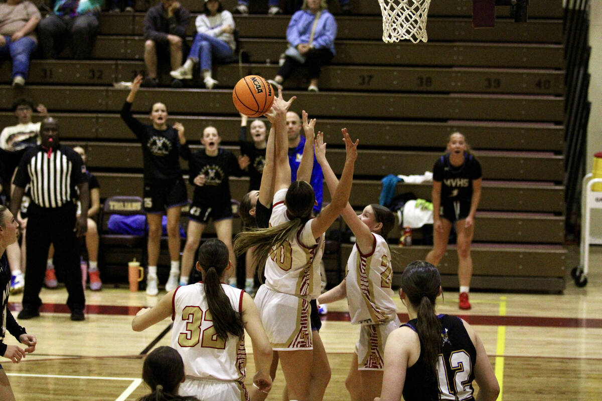 Trojans Ella Odegard and Riley Saldana double team a player from Moapa Valley during the first ...