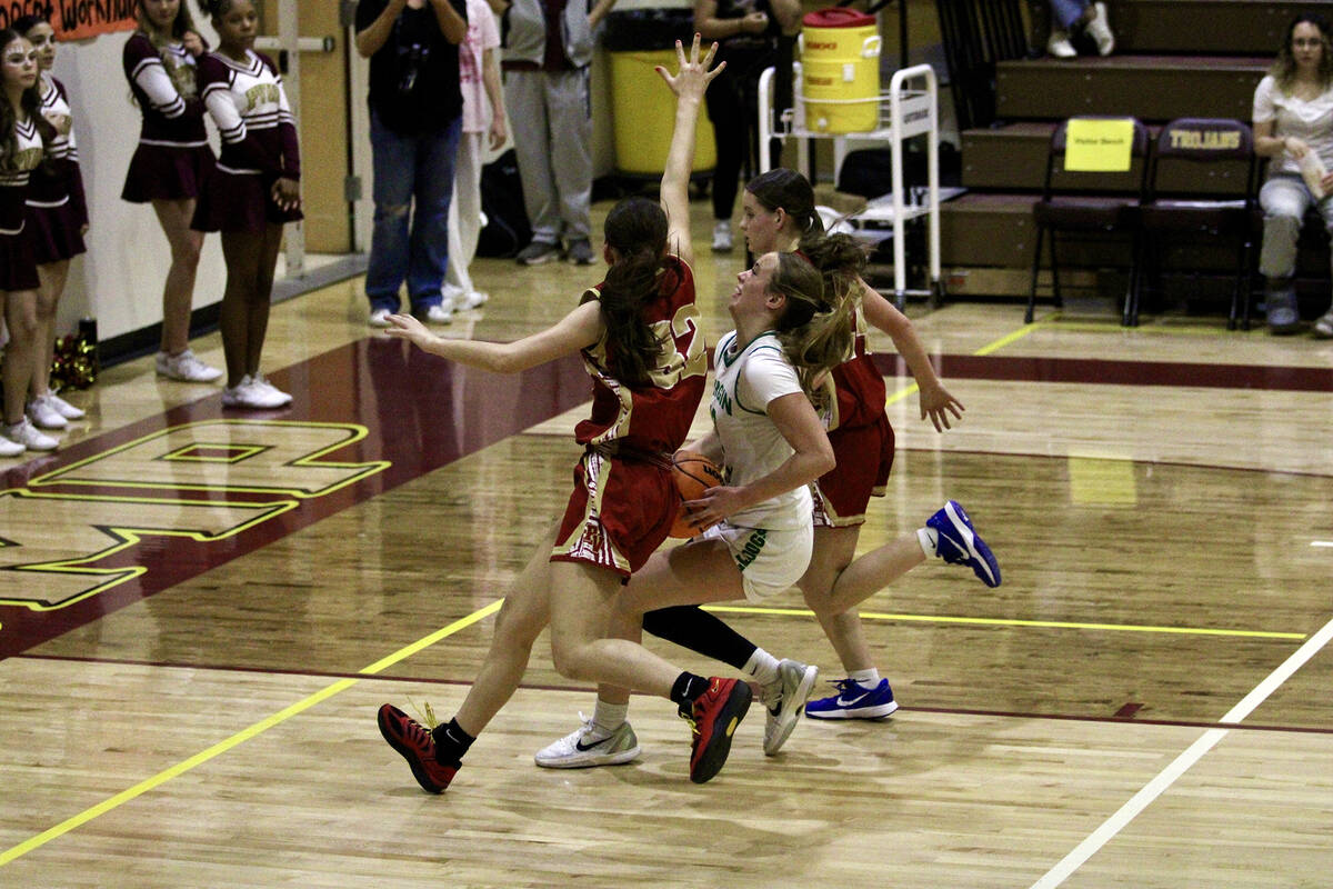 Trojans freshman Olivia Veloz and sophomore Ella Odegard do their best to contain the relentles ...
