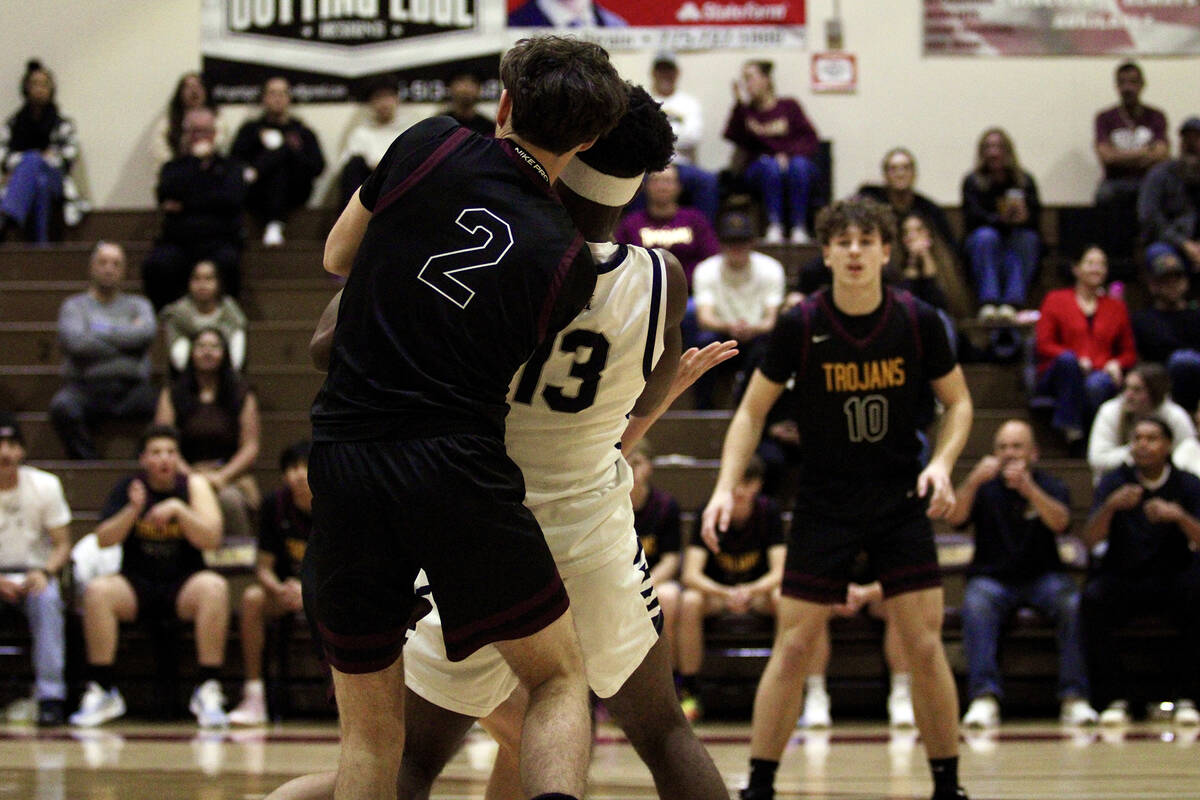 Trojan junior Lucas Gavenda does his best to rip the ball away from the Mustangs junior Uzo Nwa ...