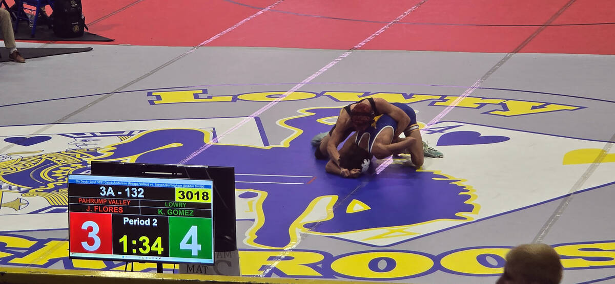 Trojans Joaquin Flores wrestles his opponent from Lowry High School during the Class 3A state c ...