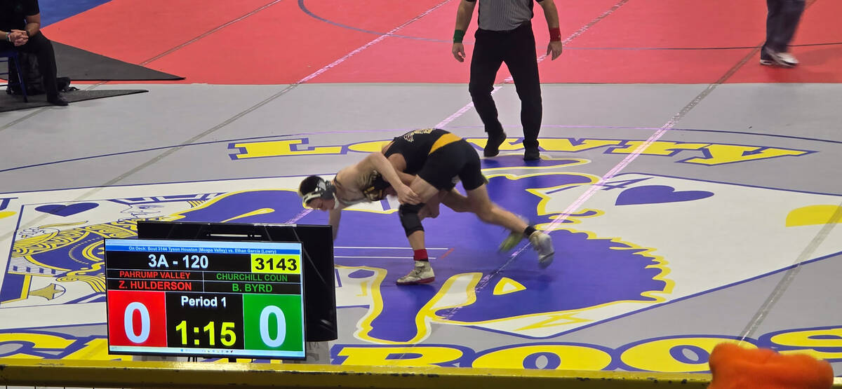 Trojans Zachary Hulderson goes up against his opponent from Churchill County High School up nor ...