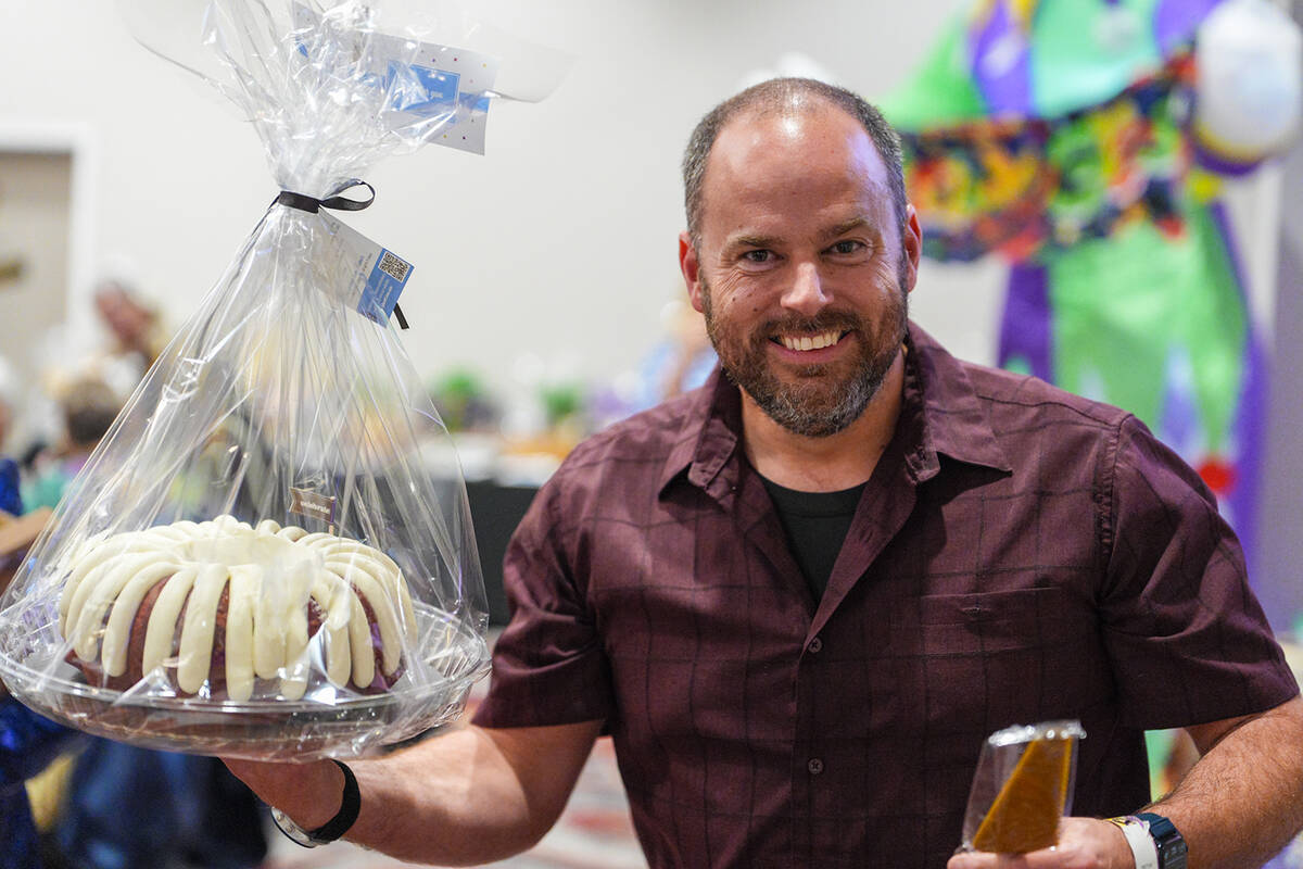 Soroptimist supporter D.J. Mills proudly displays the bundt cake he won in the Dessert Dash at ...