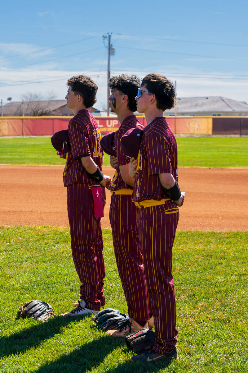 Trojans Anthony Montanez, Tony Whitney and Dominic Chicancone stand for the Pledge of Allegianc ...