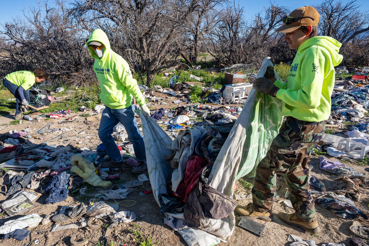 Clean Up Pahrump volunteers begin hauling the mounds of trash into the dumpster. (John Clausen/ ...