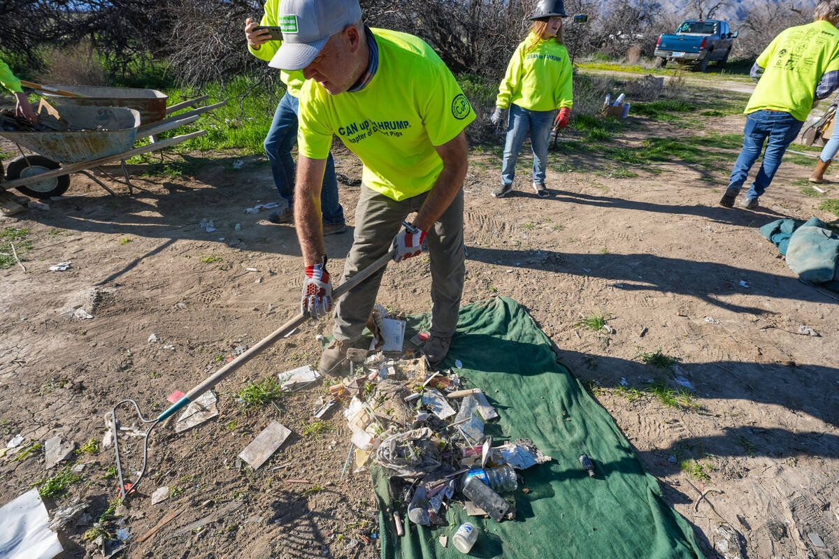 A Clean Up Pahrump volunteer rakes up small pieces of trash. (John Clausen/Pahrump Valley Times)