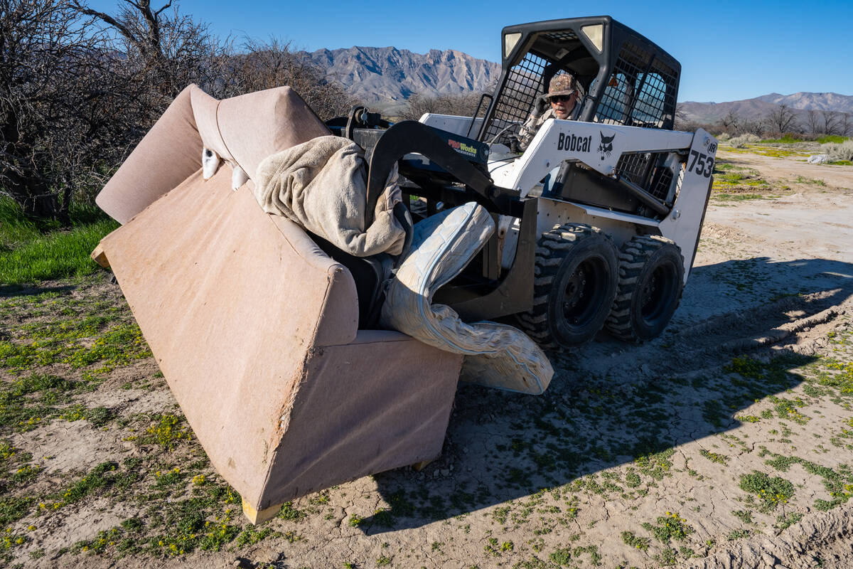 A Bobcat moves heavier objects into the dumpster. (John Clausen/Pahrump Valley Times)