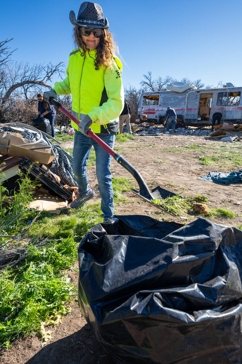 Clean Up Pahrump chapter president Faith Muello shoves trash into a bag. (John Clausen/Pahrump ...