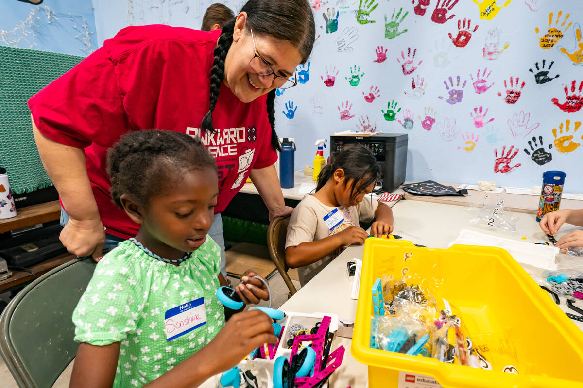 Awkward Silence 4-H head coach Jennifer Riendeau helps youngsters assemble their Lego kits at t ...