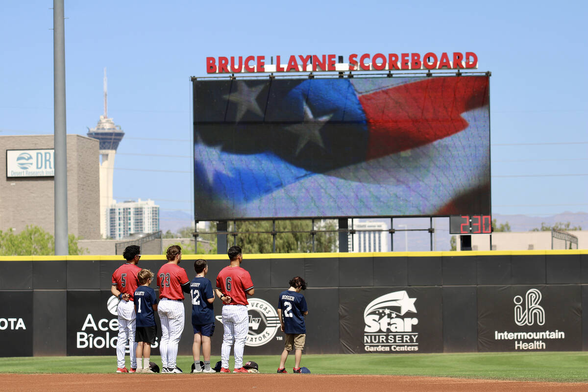 UNLV's Drew Barragan, Gunnar Myro and Marcos Rosales stand by members of a travel ball program ...