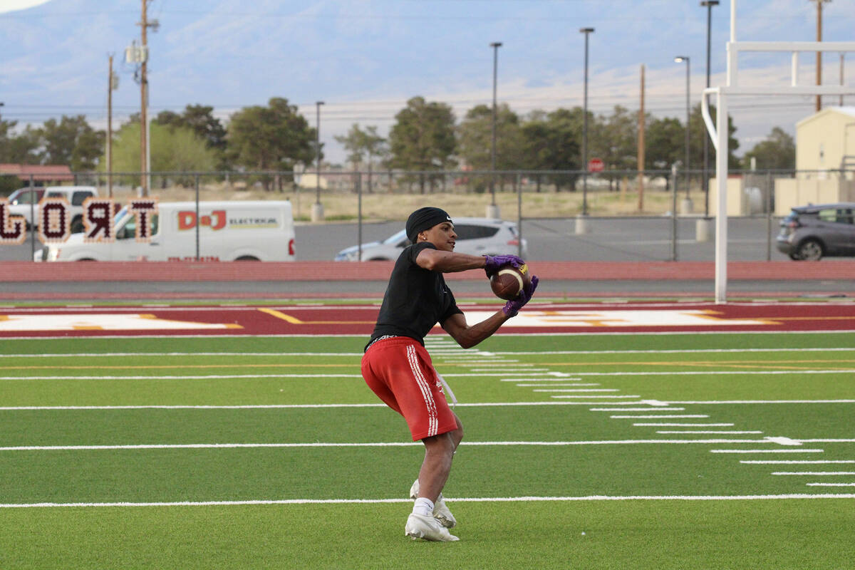 Pahrump Valley High School junior Angel Ware reels in quick pass during the Trojans' seven-on-s ...