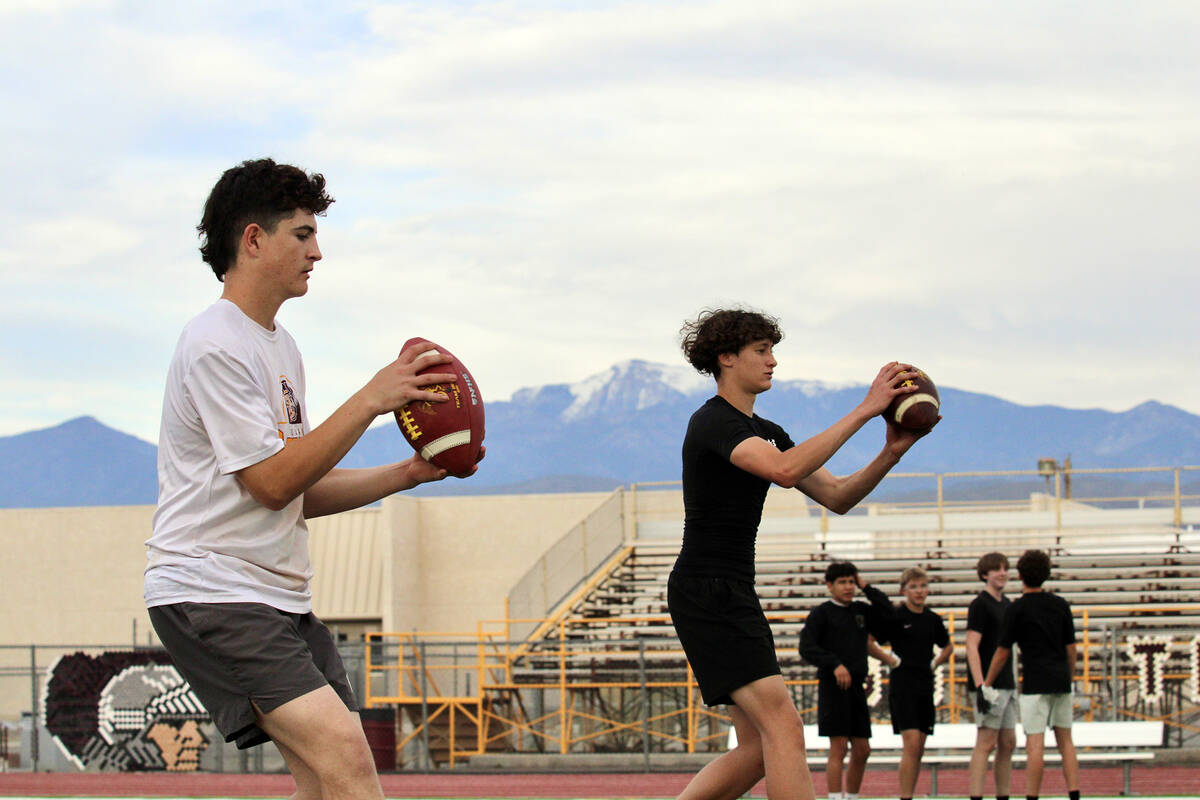 Pahrump Valley High School quarterbacks Anthony Montanez and Evan Strain practice throwing to r ...