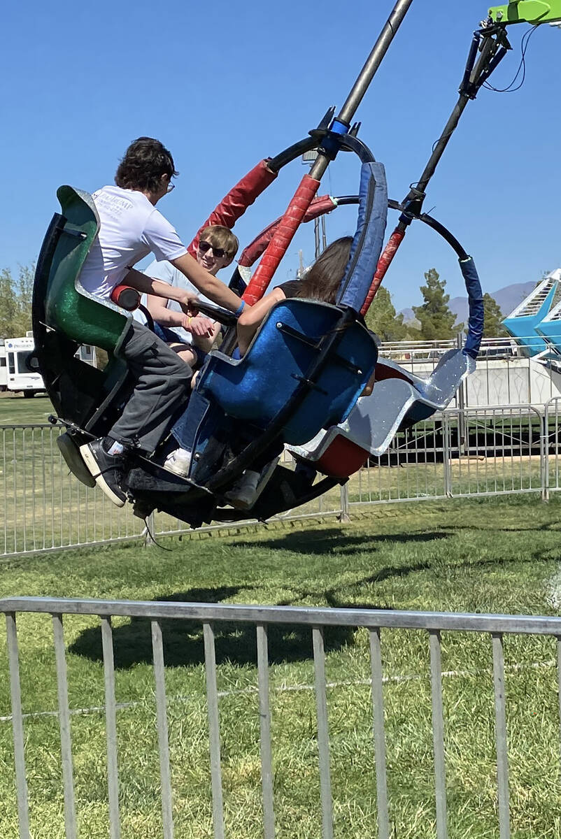 Swirling around on one of the rides at the Pahrump Chili Cook-Off carnival, attendees grin with ...