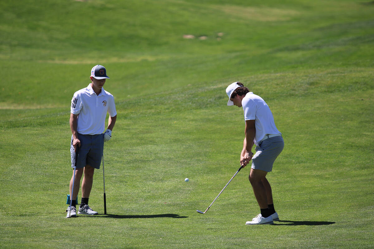 Pahrump Valley High School juniors Aaron Rily and TC Hone scramble together on the back nine ho ...