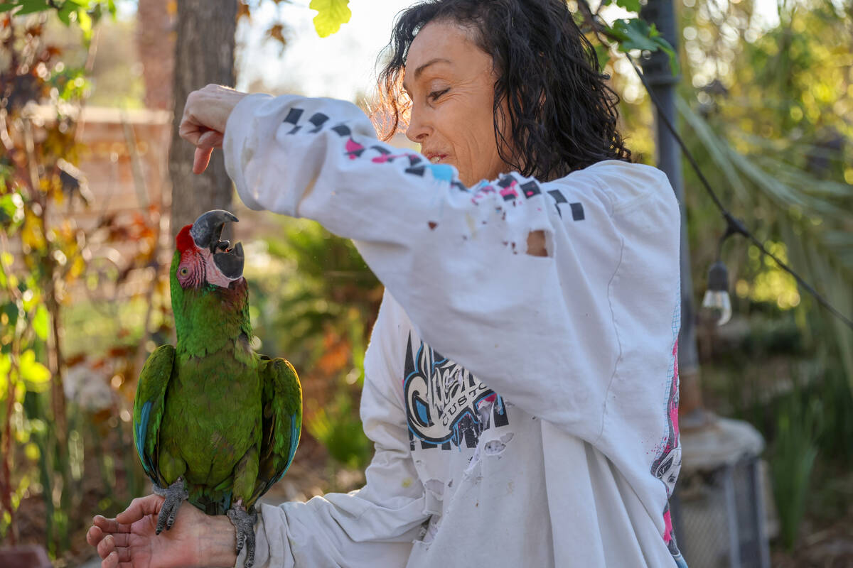 Heidi Fleiss communicates with a macaw named Gin in her backyard on Wednesday, March 18, 2026, ...