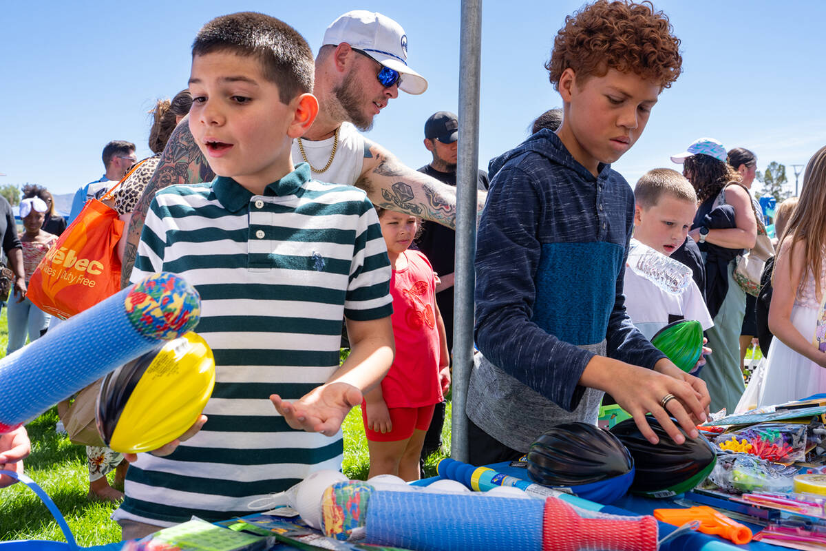 Youngsters peruse a pile of prizes at Easter at Simkins Park, picking out just what they would ...