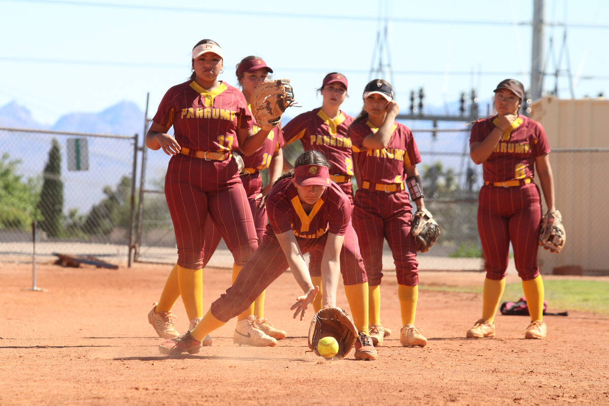 The Lady Trojans take warm-up grounders prior to the start of their league game contest against ...
