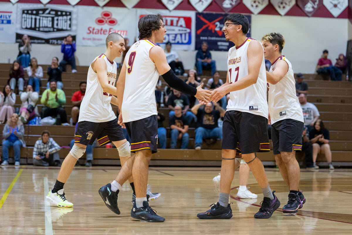 The Trojans boys volleyball team gathers midcourt during a set point in their home league game ...