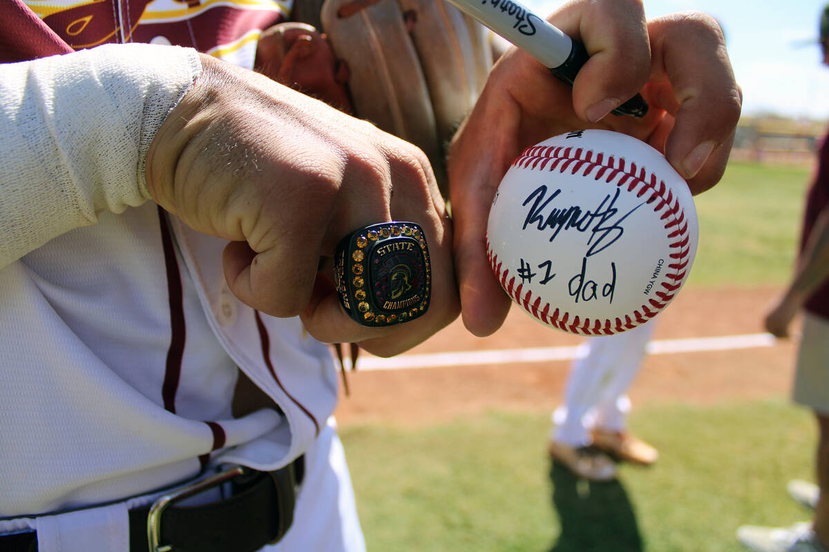 Senior Kayne Horibe signs a ball for his father Rich, emulating how he used to write on his fat ...