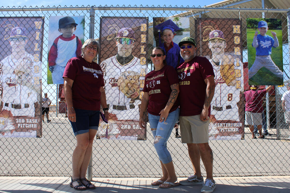 Senior Leland Delgado's family poses in front of his senior banner prior to the first pitch aga ...