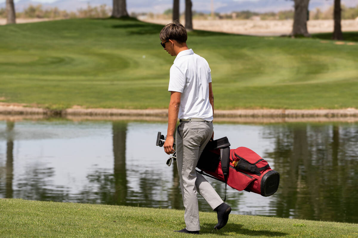 Pahrump Valley High School boys golf senior Cayden Cowley walks barefoot to his next hole durin ...