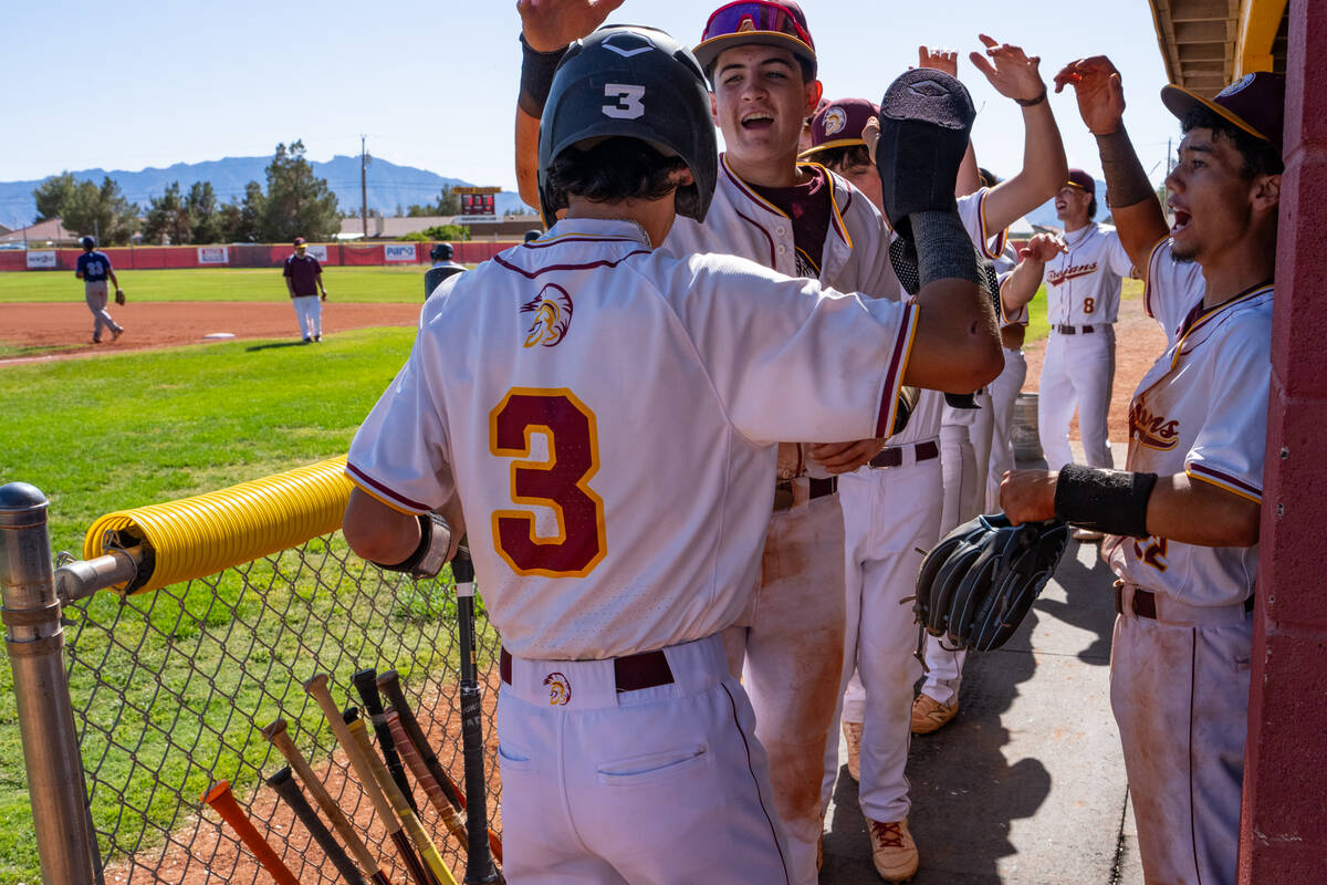 Pahrump Valley High School senior Vinny Whitney is mobbed by teammates Anthony Montanez and Ton ...