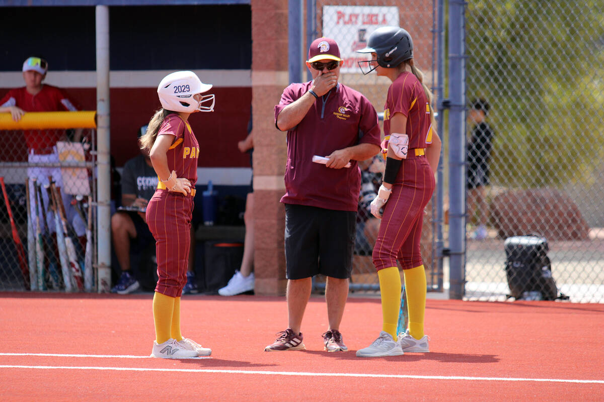 Trojan teammates Riley Saldana and Aspen Middaugh chat with assistant head coach, Rich Lauver, ...